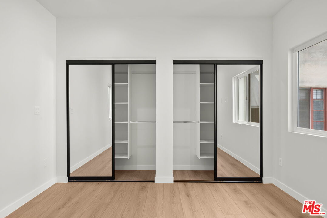 128 South Swall Drive, Unit 1/2 Los Angeles, CA 90048 - Photo 17 of 32 a view of an empty room with wooden floor and closet