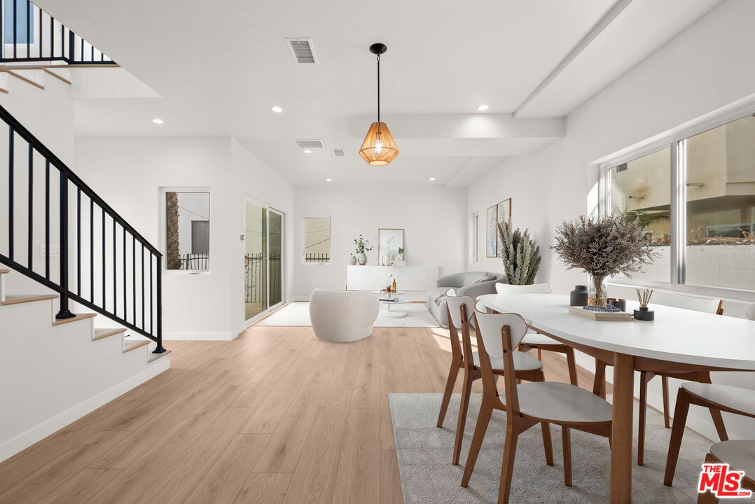 128 South Swall Drive, Unit 1/2 Los Angeles, CA 90048 - Photo 2 of 32 a dining room with wooden floor furniture and a chandelier