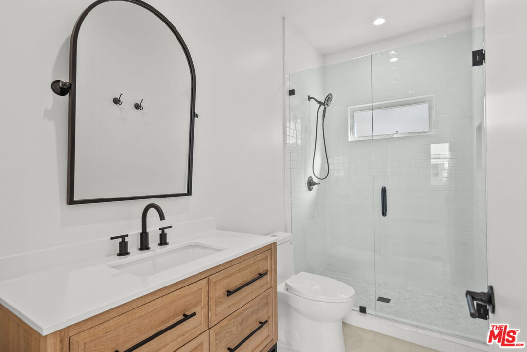 128 South Swall Drive, Unit 1/2 Los Angeles, CA 90048 - Photo 25 of 32 a bathroom with a sink a toilet a mirror and shower
