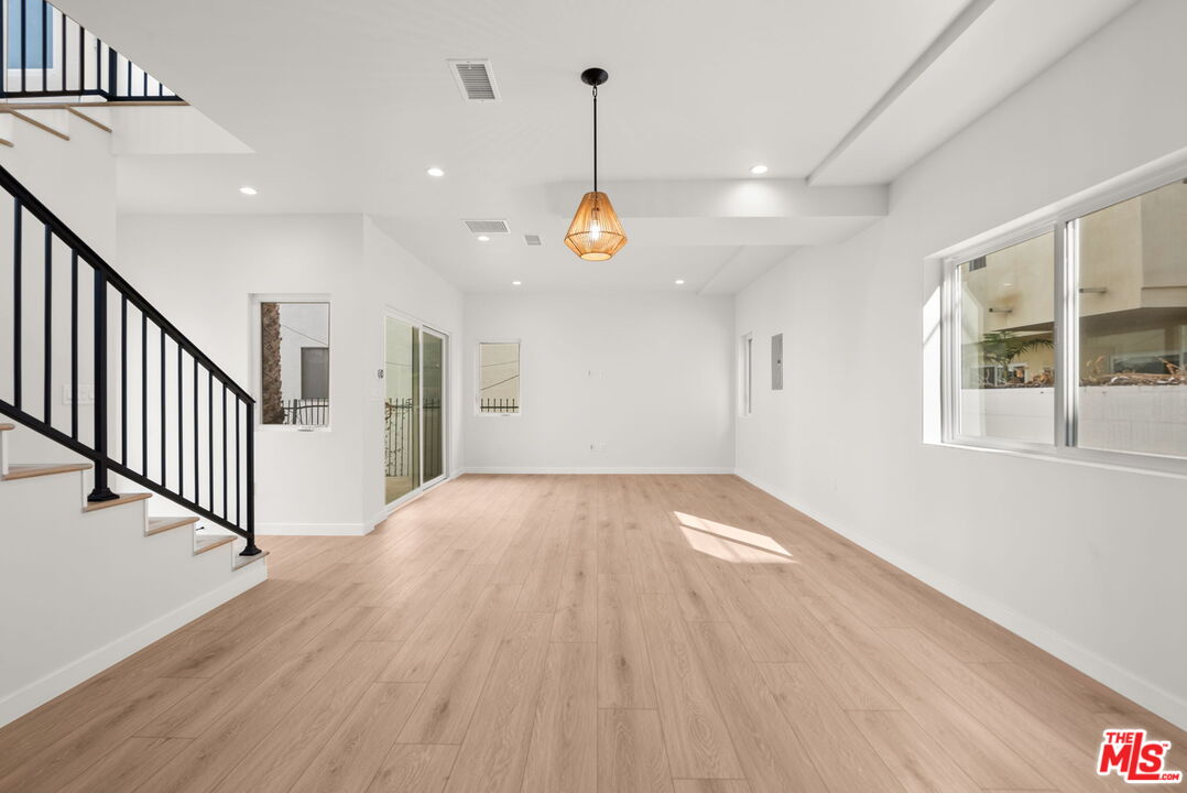 128 South Swall Drive, Unit 1/2 Los Angeles, CA 90048 - Photo 6 of 32 a view of empty room with wooden floor and windows