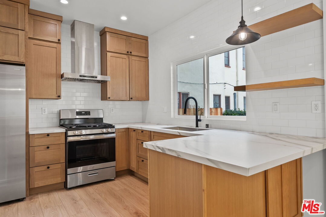128 South Swall Drive, Unit 1/2 Los Angeles, CA 90048 - Photo 7 of 32 a kitchen with stainless steel appliances granite countertop a sink a stove and a refrigerator