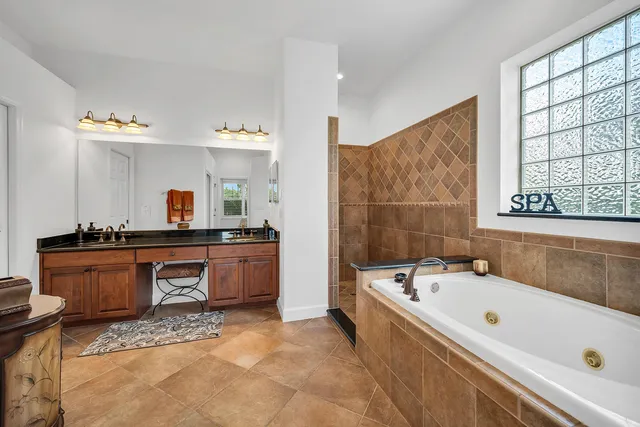 a large spacious bathroom with a tub sink and mirror