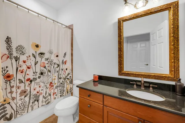 a bathroom with a granite countertop sink a toilet and a mirror