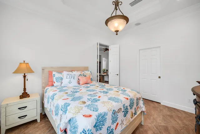 a bedroom with a large bed and a chandelier