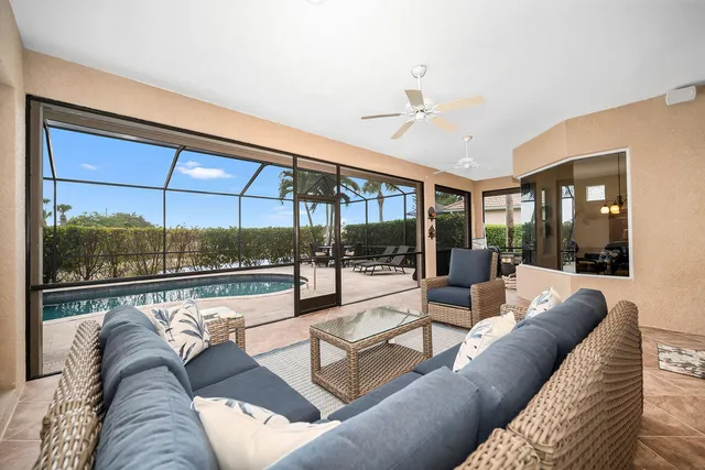 a living room with couch floor to ceiling window and wooden floor