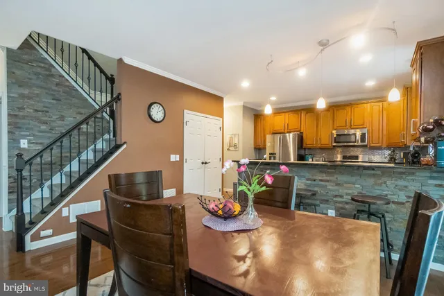 a kitchen with stainless steel appliances granite countertop a stove a refrigerator a microwave a sink and chairs