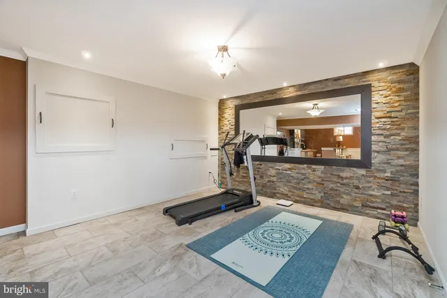 a view of a kitchen with kitchen island a flat screen tv a island and stainless steel appliances