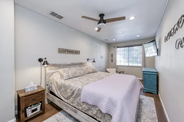 a bedroom with a bed a dresser and a window