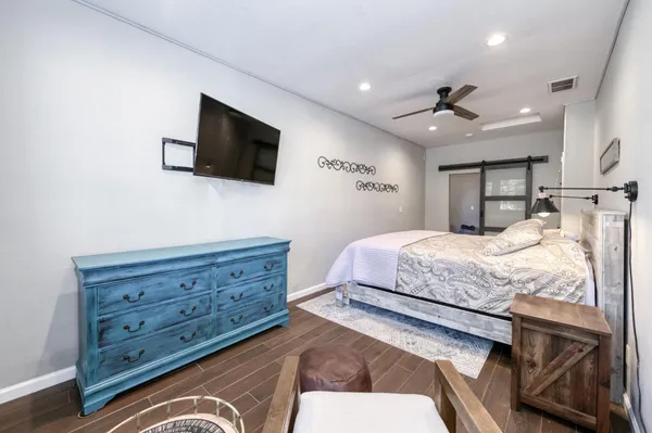a bedroom with a bed a flat screen tv and a couch