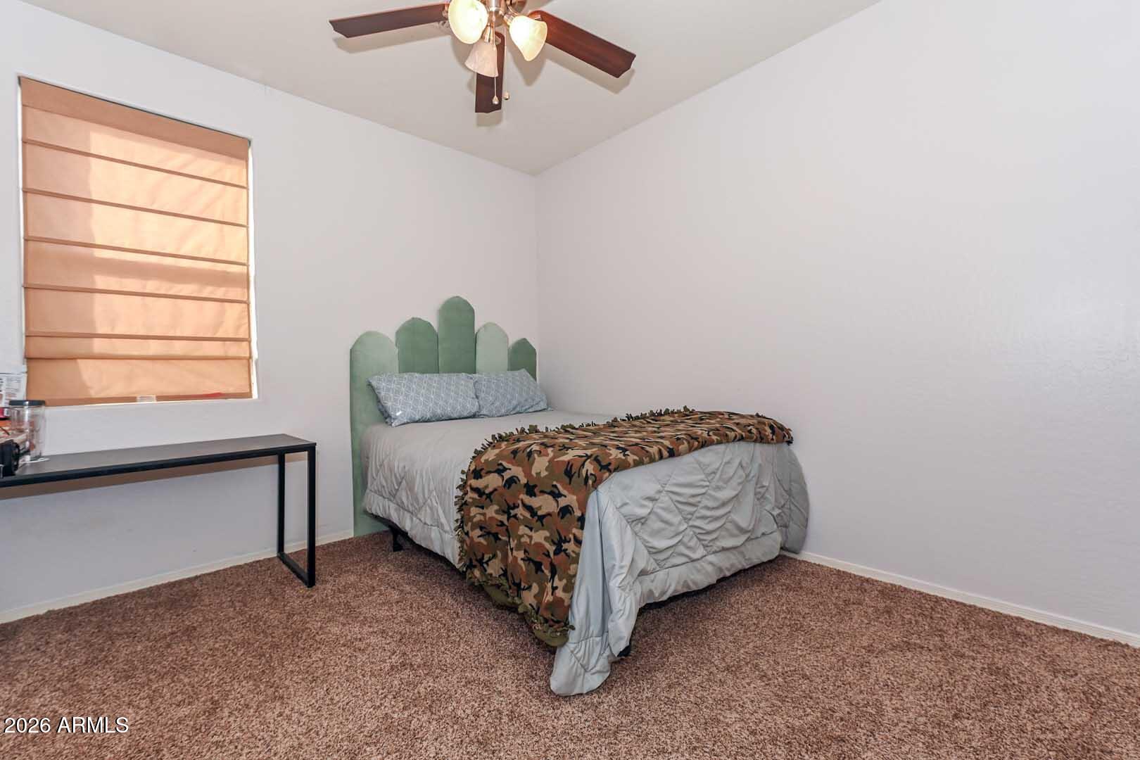 11929 West Alvarado Road Avondale, AZ 85392 - Photo 30 of 39 a bed sitting in a bedroom next to a window