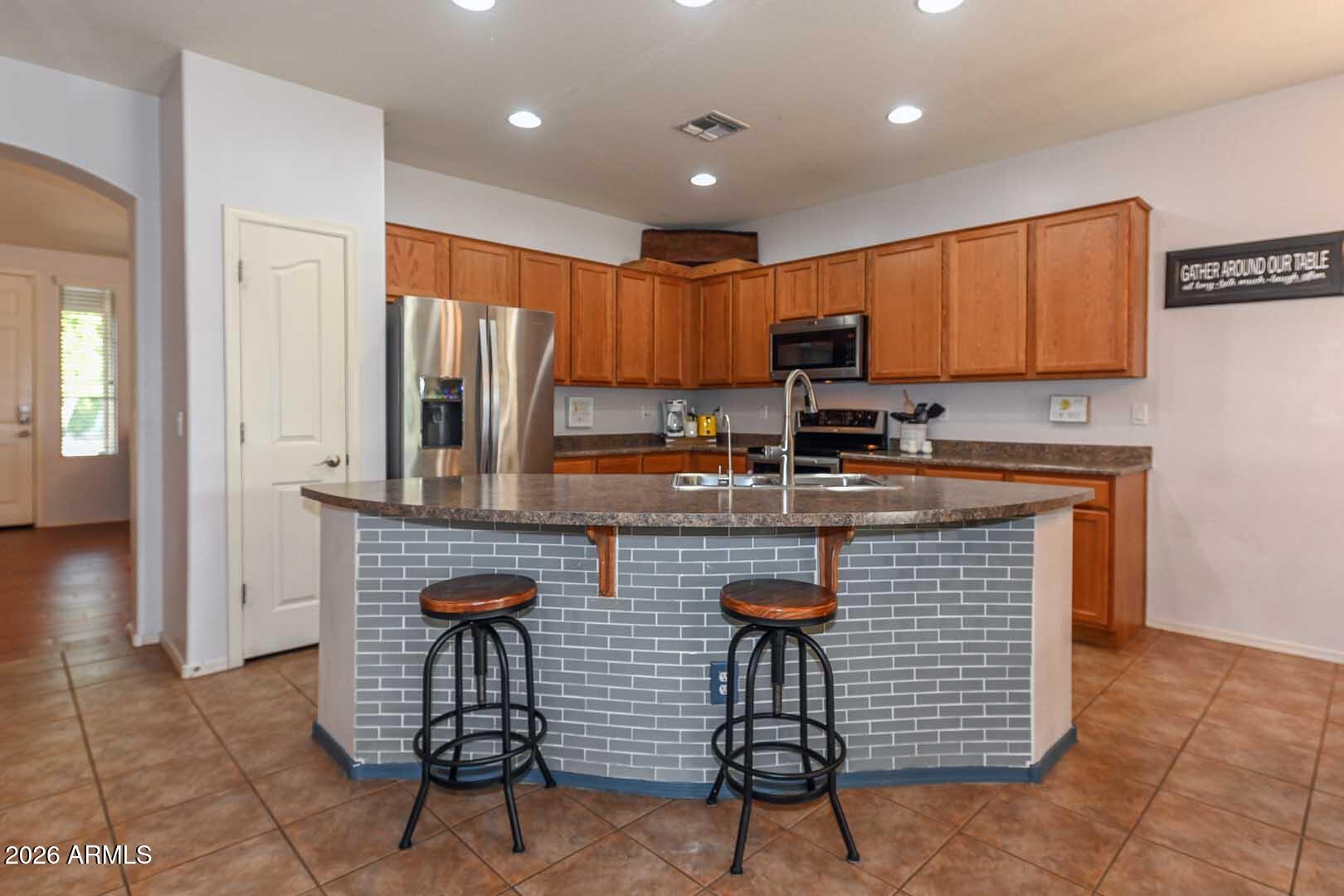 11929 West Alvarado Road Avondale, AZ 85392 - Photo 3 of 39 a kitchen with stainless steel appliances granite countertop a stove a sink a microwave a refrigerator and cabinets