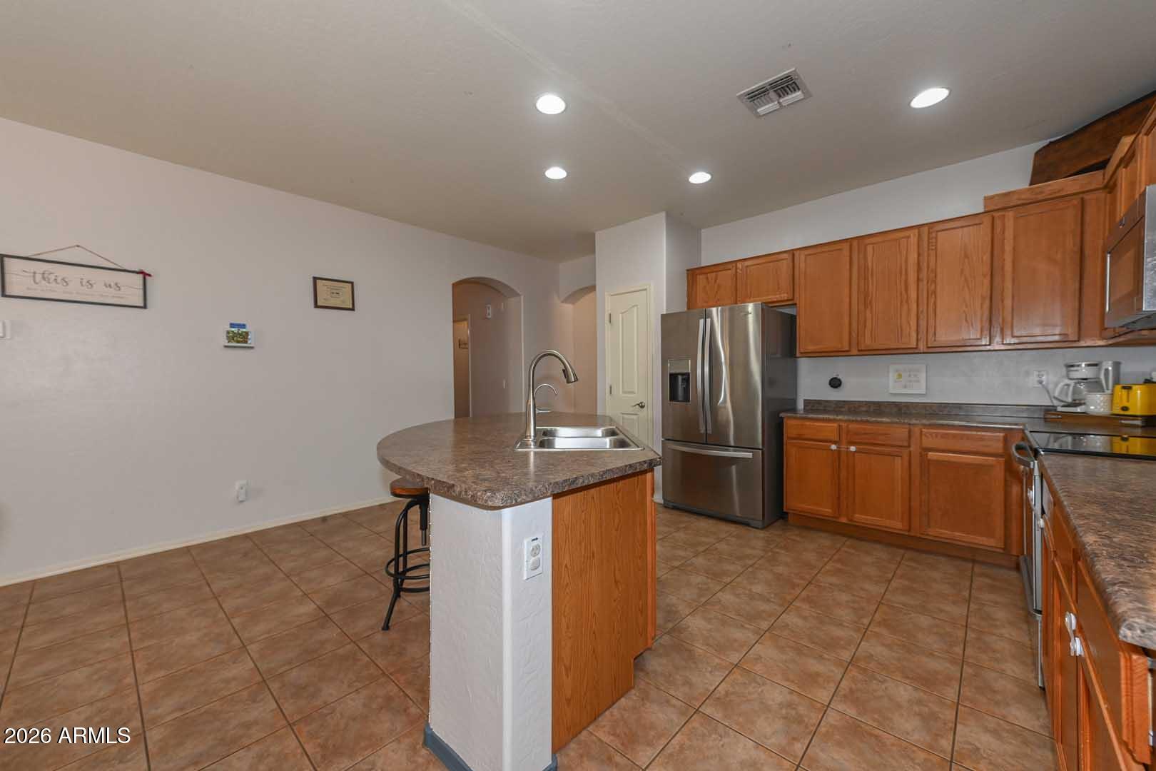 11929 West Alvarado Road Avondale, AZ 85392 - Photo 4 of 39 a kitchen with stainless steel appliances granite countertop a refrigerator a stove a sink and a microwave