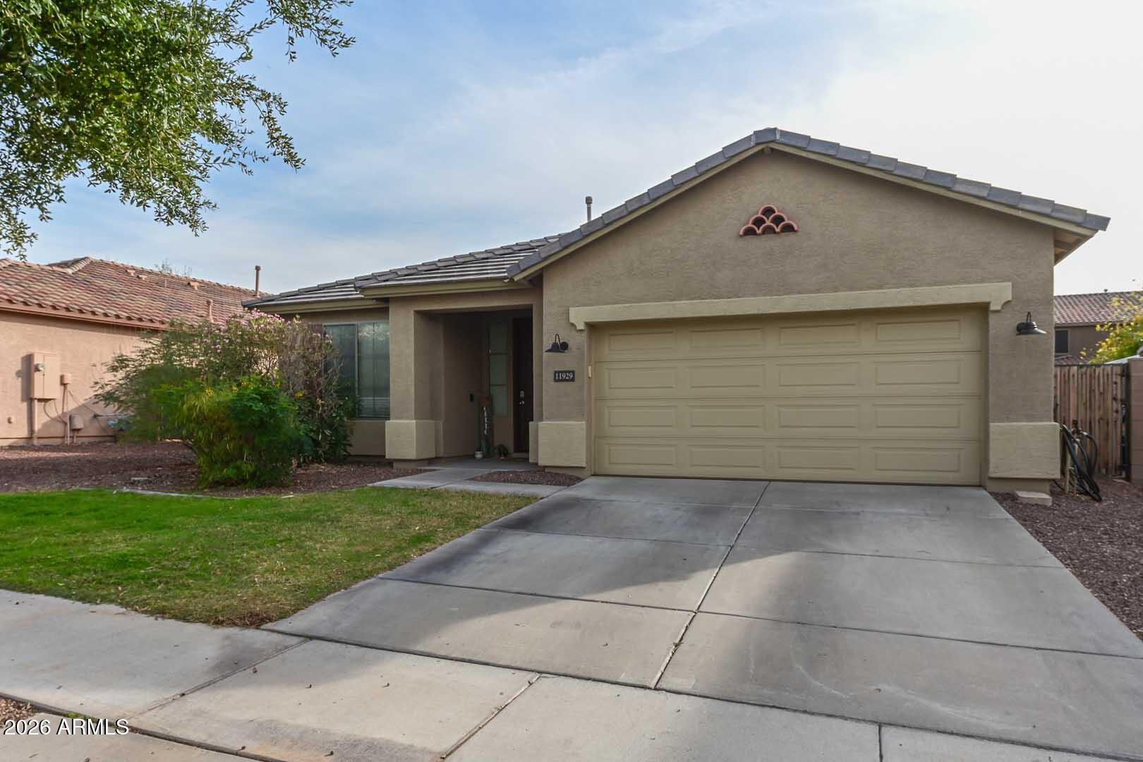 11929 West Alvarado Road Avondale, AZ 85392 - Photo 8 of 39 a front view of a house with a yard and garage
