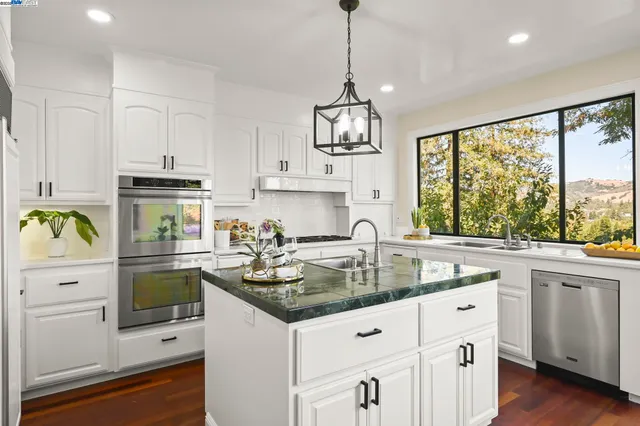 a kitchen with white cabinets and appliances