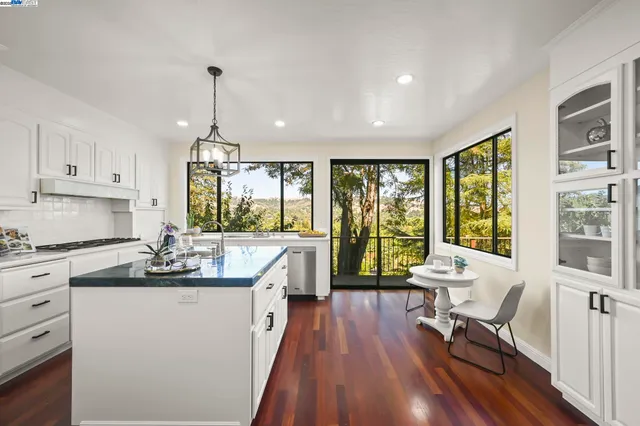 a kitchen with kitchen island a large window cabinets a sink and stainless steel appliances