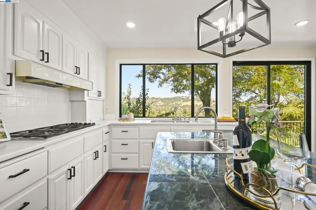 a kitchen with stainless steel appliances granite countertop a stove a sink and cabinets