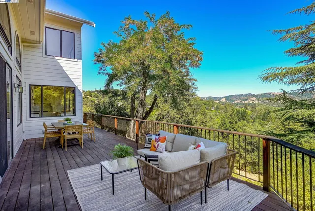 a balcony with wooden floor table and chairs