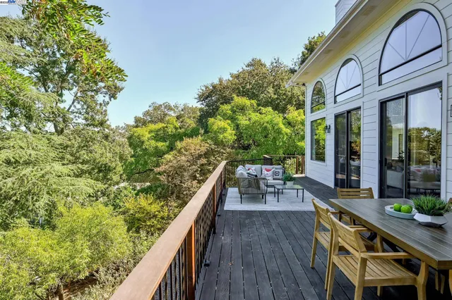 a terrace of a house with wooden floor outdoor seating and yard in the back