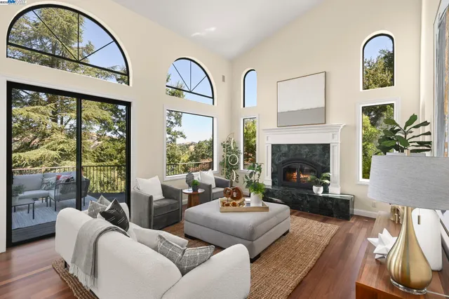 a living room with furniture a fireplace and a large window