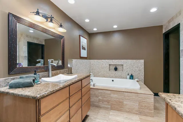 a bathroom with a sink a large mirror and a bathtub