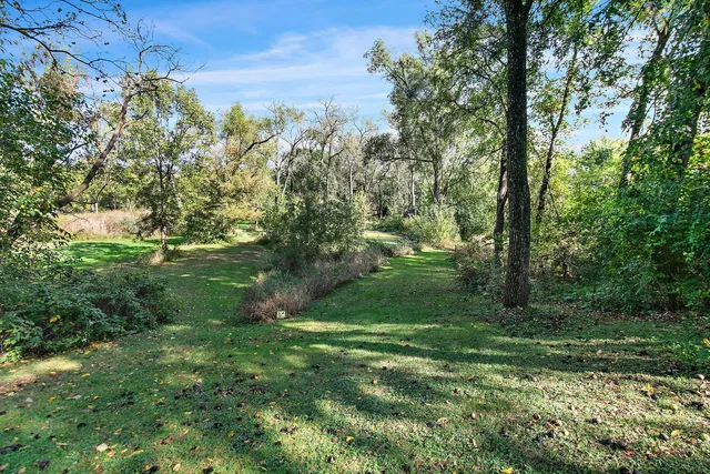 an aerial view of residential house with outdoor space and trees around
