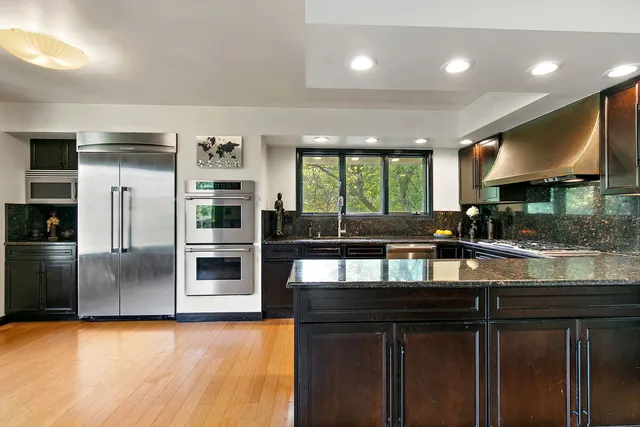 a kitchen with stainless steel appliances granite countertop a stove a sink and a refrigerator