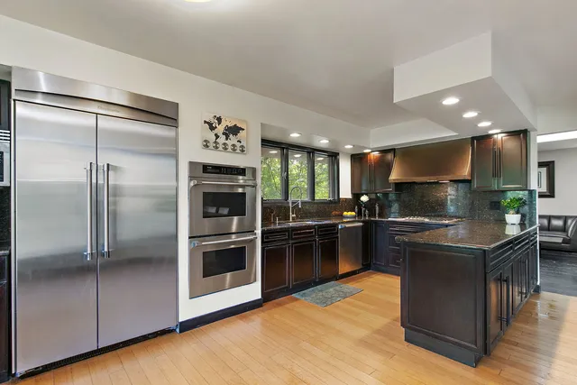 a kitchen with kitchen island a counter top space a sink and stainless steel appliances