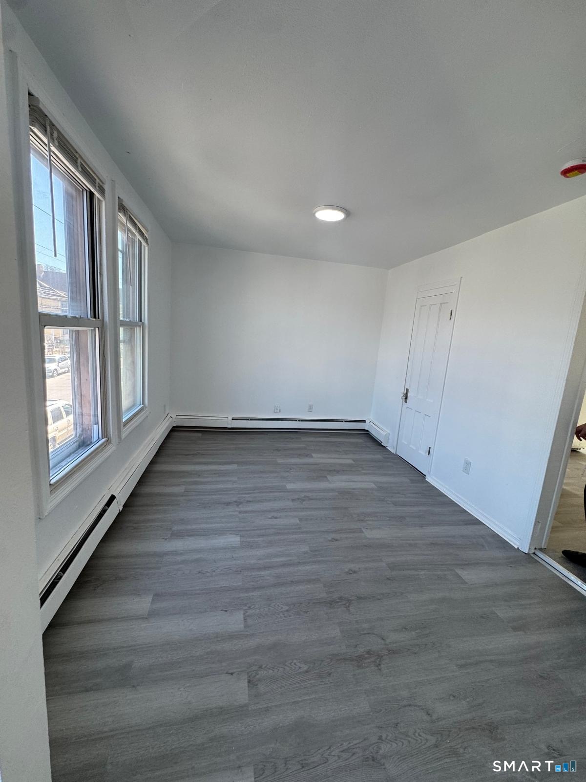 265 6th Street Bridgeport, CT 06607 - Photo 5 of 9 a view of an empty room with wooden floor and a window