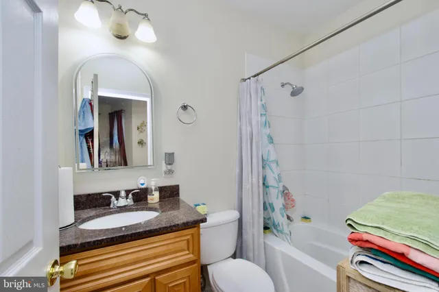 a bathroom with a granite countertop sink toilet a mirror and shower