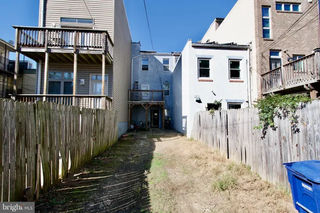 a view of a white building with wooden fence