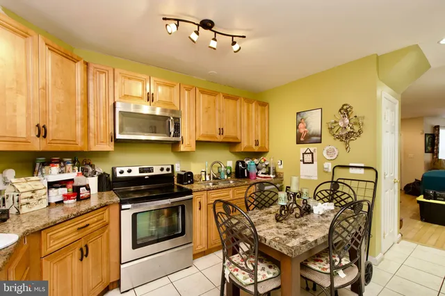 a kitchen with stainless steel appliances a stove a sink cabinets and a microwave