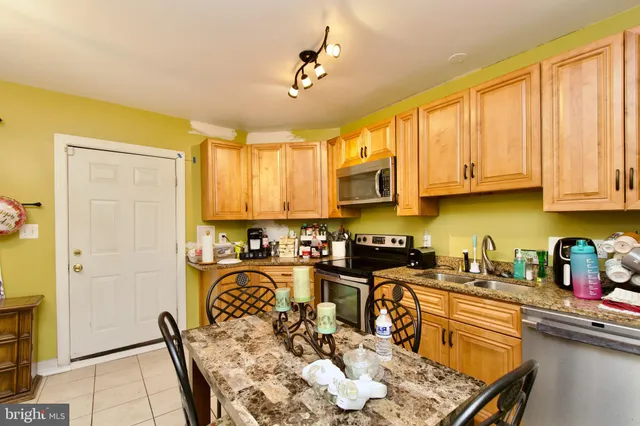 a kitchen with stainless steel appliances granite countertop a stove top oven a sink dishwasher and cabinets with wooden floor