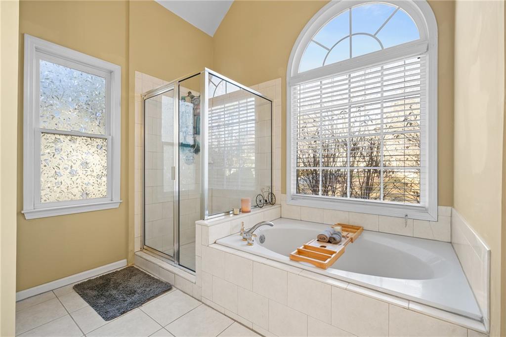 8935 Mountain Ridge Circle Ball Ground, GA 30107 - Photo 20 of 56 a bathroom with a tub a window and a shower