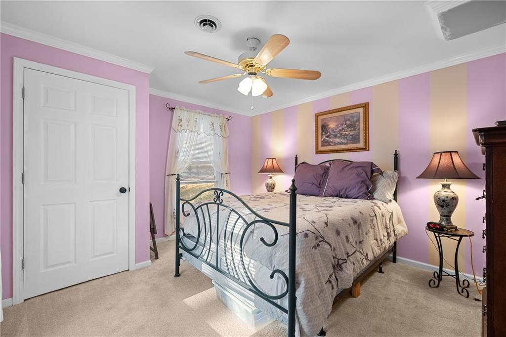 8935 Mountain Ridge Circle Ball Ground, GA 30107 - Photo 29 of 56 a bedroom with a bed and a chandelier