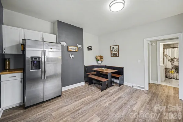 a room with a refrigerator and a wooden floor