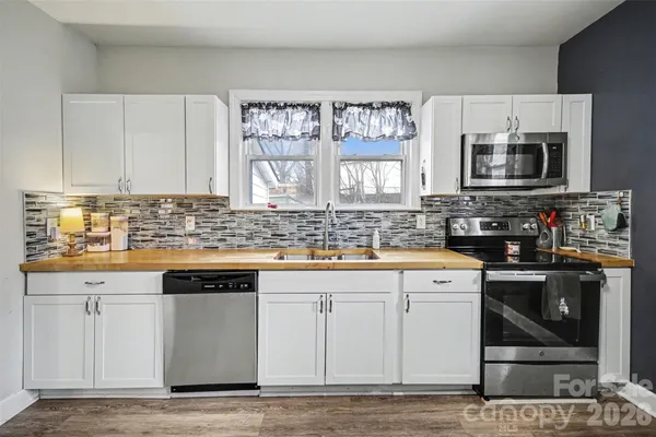 a kitchen with stainless steel appliances granite countertop a stove a sink and a microwave