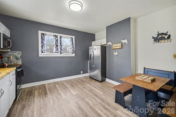 a view of a kitchen with fridge and wooden floor