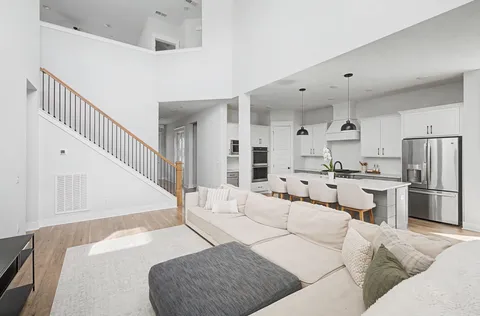 a living room with furniture a flat screen tv and a potted plant
