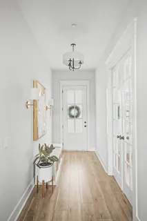 a view of a livingroom with wooden floor and furniture