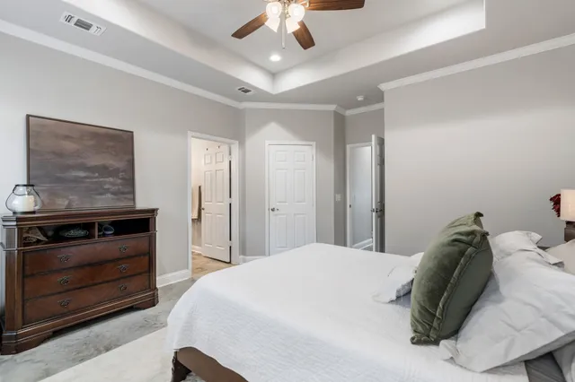 a spacious bedroom with a bed and a ceiling fan