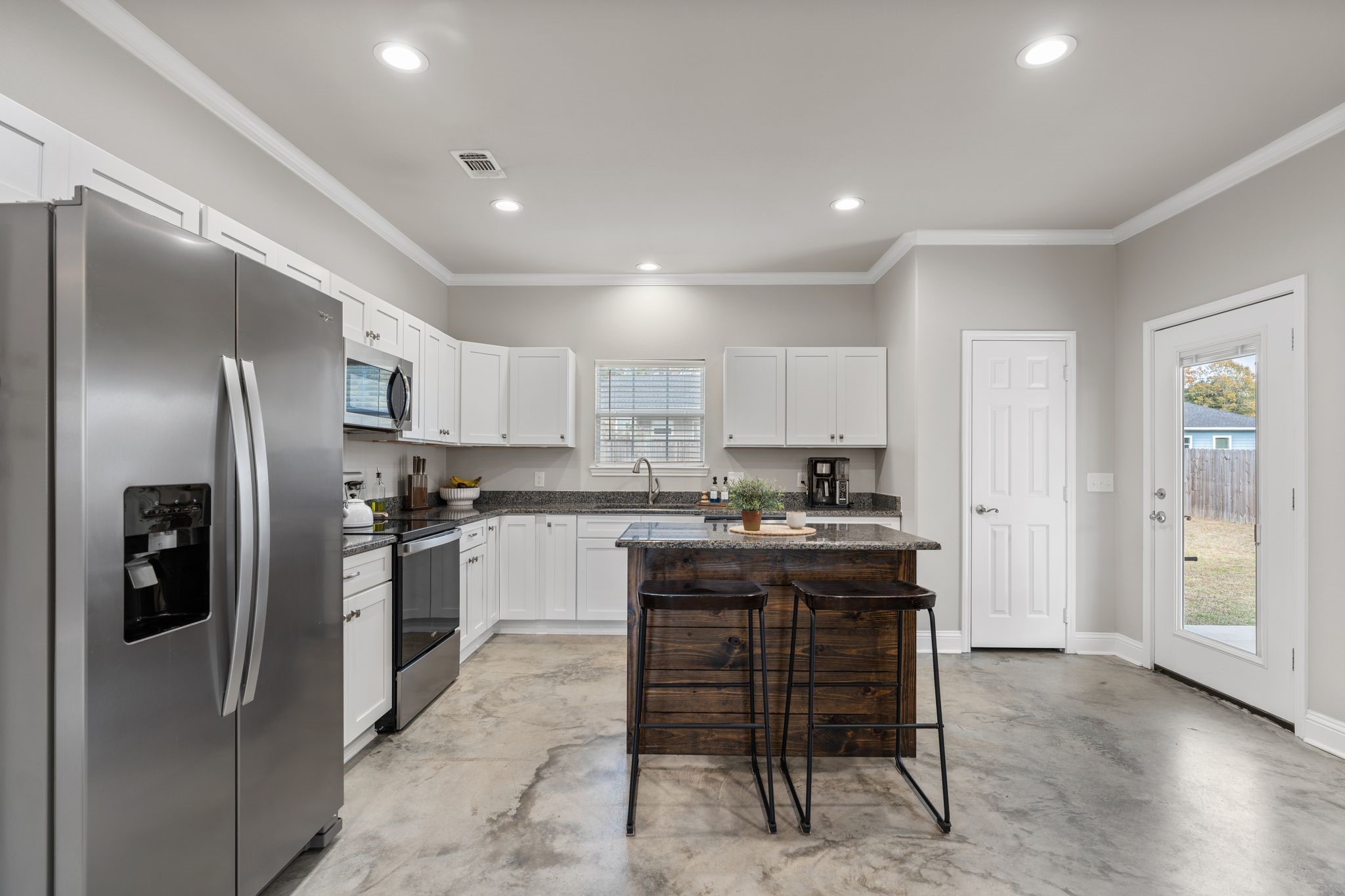 413 East Spruce Street Huntington, TX 75949 - Photo 5 of 37 a kitchen with kitchen island a refrigerator stove microwave and cabinets
