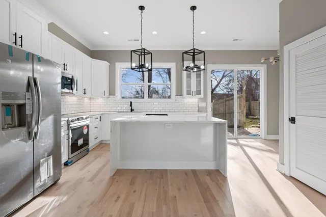 a view of kitchen with sink microwave and refrigerator