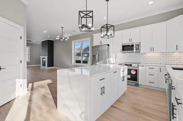 a kitchen with stainless steel appliances kitchen island granite countertop a stove a sink and a refrigerator