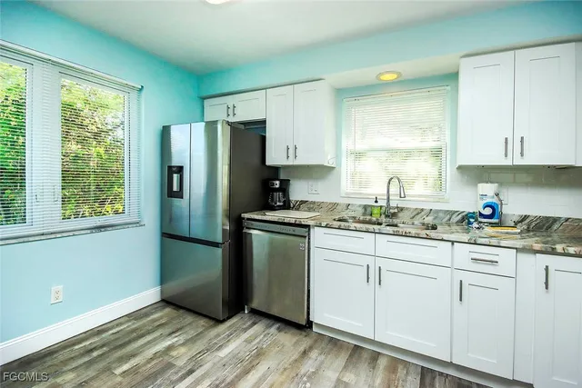 a kitchen with granite countertop white cabinets and white appliances