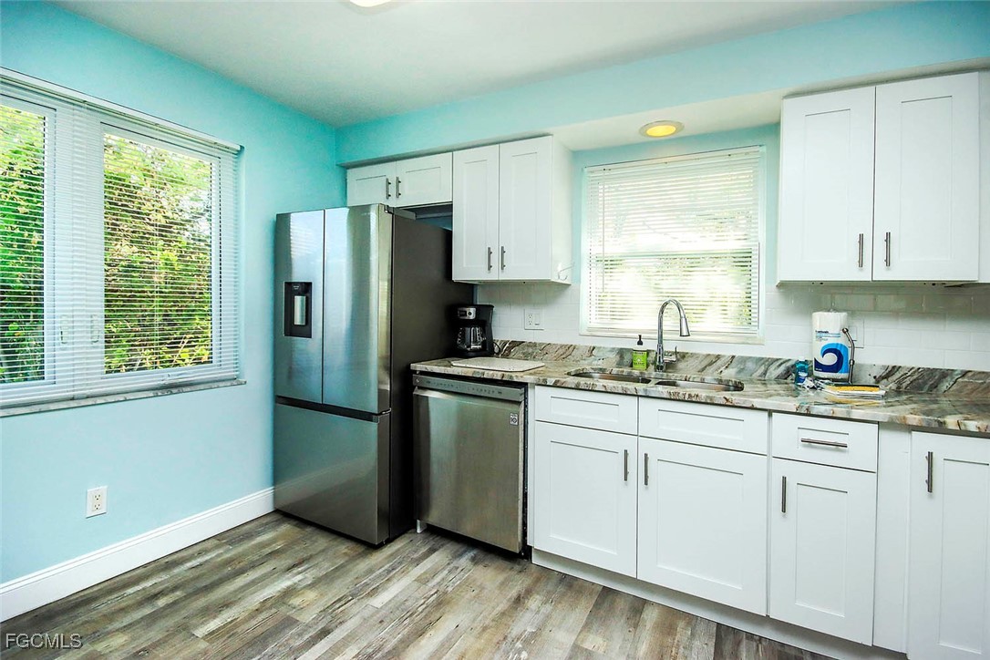 4560 Brainard Bayou Road Sanibel, FL 33957 - Photo 11 of 32 a kitchen with granite countertop white cabinets and white appliances
