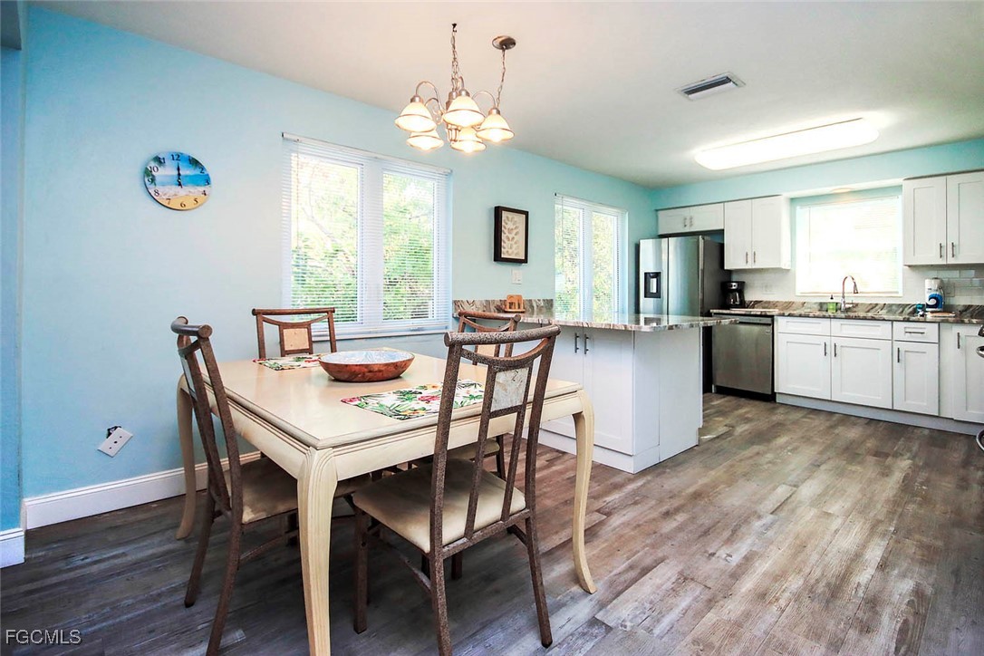 4560 Brainard Bayou Road Sanibel, FL 33957 - Photo 12 of 32 a view of a dining room with furniture and wooden floor