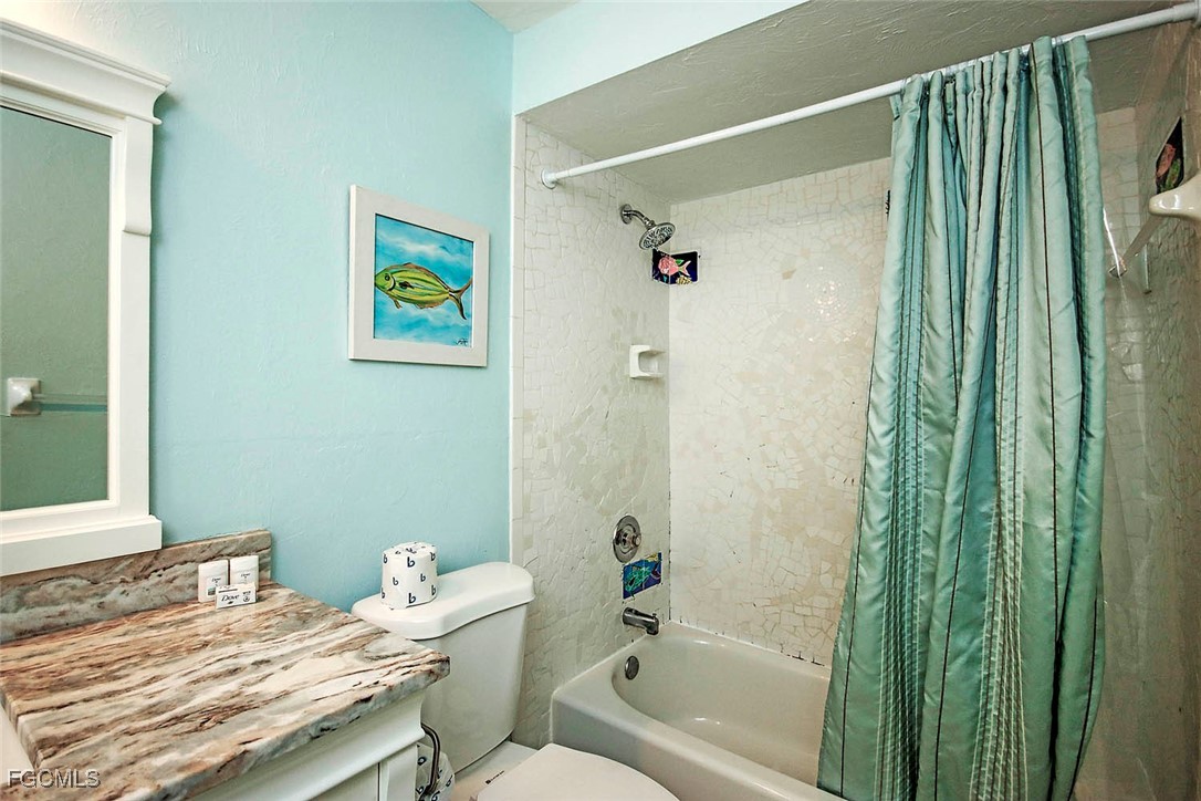 4560 Brainard Bayou Road Sanibel, FL 33957 - Photo 19 of 32 a bathroom with a granite countertop sink a toilet and shower