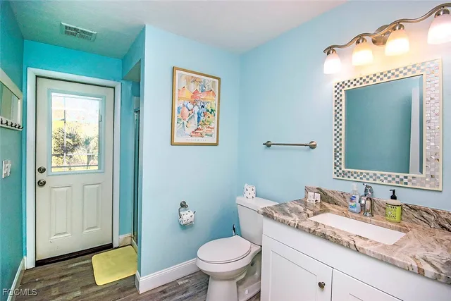 a bathroom with a granite countertop toilet sink and mirror