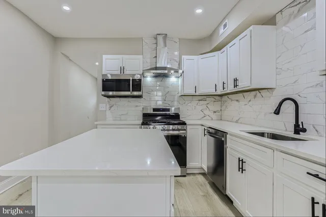 a kitchen with stainless steel appliances a stove sink and cabinets