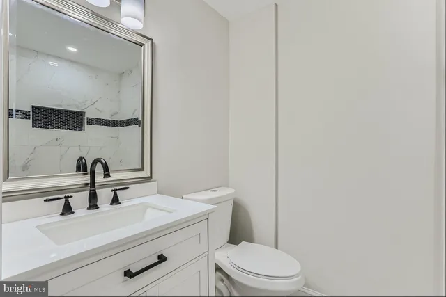 a bathroom with a sink a toilet and mirror